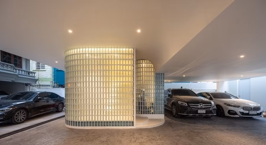 Ngôi nhà nằm đối diện với ngôi nhà cũ của bố mẹ gia chủ. Tầng một được thiết kế như một không gian mở với nhà để xe và một lối đi kết nối với ngôi nhà cũ.