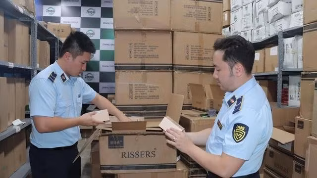 Đoàn kiểm tra của Tổng cục Quản lý thị trường kiểm tra kho nước hoa nghi là hàng nhập lậu ở Hà Nội. ẢNH: LƯU QUYÊN