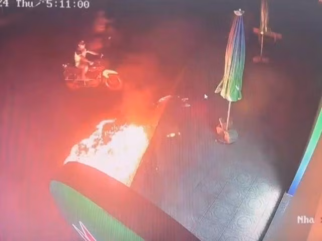 Người đàn ông cầm chai nhựa nghi "bom xăng" ném vào một ngân hàng tại TX.Sông Cầu vào rạng sáng 3.10. ẢNH: CÔNG AN CUNG CẤP