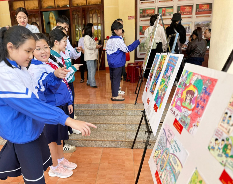 Học sinh xem trưng bày tranh tham gia cuộc thi “Đại sứ học đường trong khắc phục hậu quả bom mìn, vật liệu nổ do chiến tranh để lại”. Ảnh: H.L