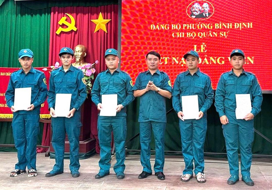 Kết nạp đảng viên mới trong lực lượng dân quân tự vệ ở phường Bình Định. Ảnh: N.H