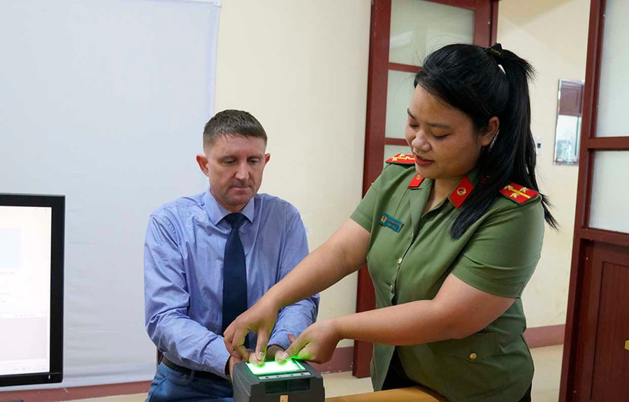 Ông Dunn Roy được hướng dẫn làm thủ tục cấp định danh điện tử mức độ 2. Ảnh: Thúy Trinh