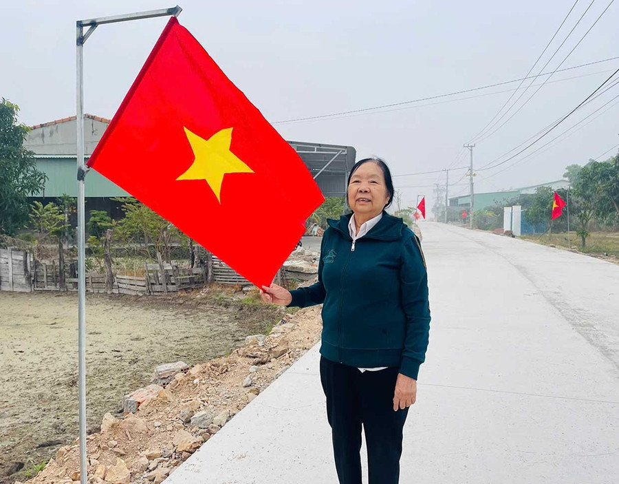 Bà Vũ Thị Lý vui mừng khi tuyến đường trước nhà được mở rộng, sạch đẹp, khang trang. Ảnh: Vũ Chi