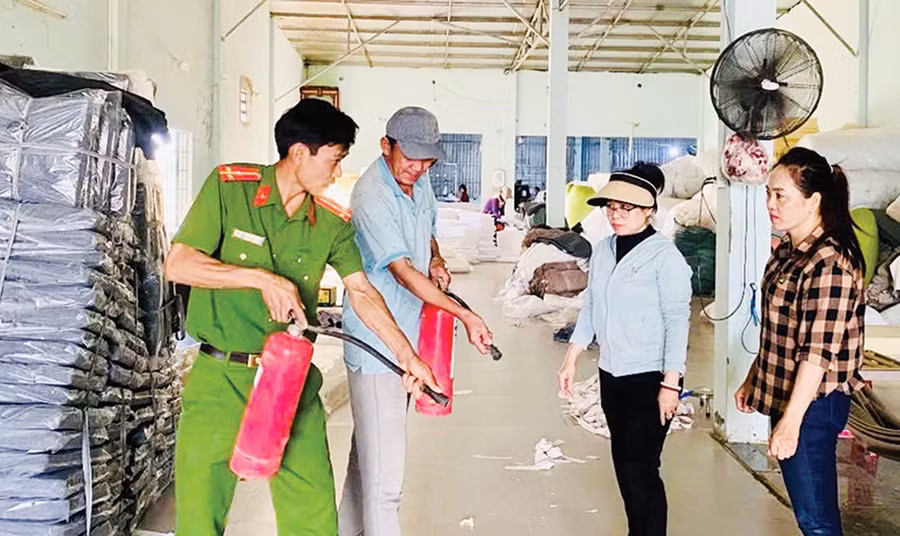 Công an phường Quy Nhơn Bắc hướng dẫn người dân cách sử dụng bình chữa cháy cầm tay. Ảnh: K.A