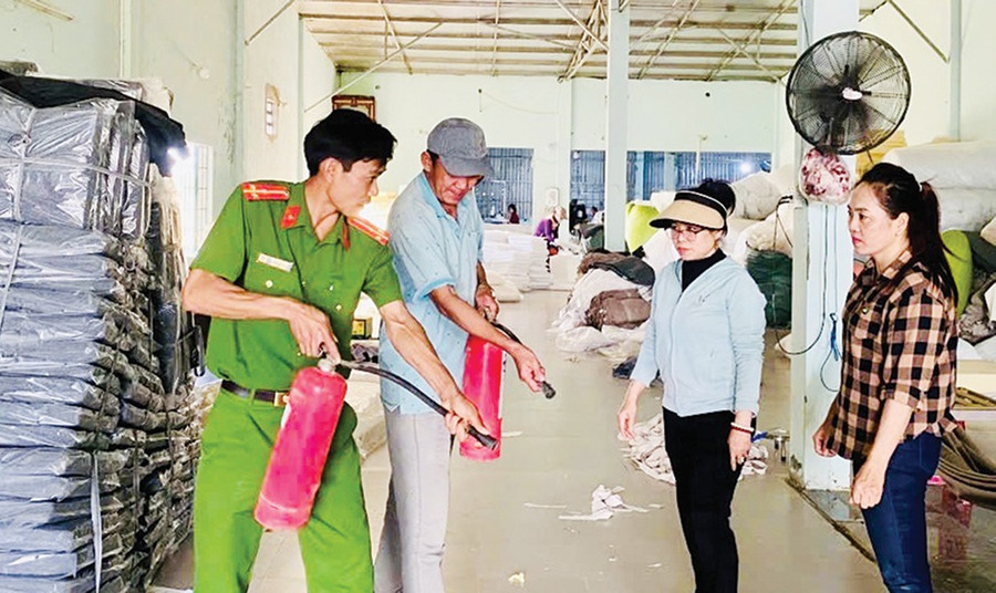 Công an phường Quy Nhơn Bắc hướng dẫn người dân cách sử dụng bình chữa cháy cầm tay. Ảnh: K.A