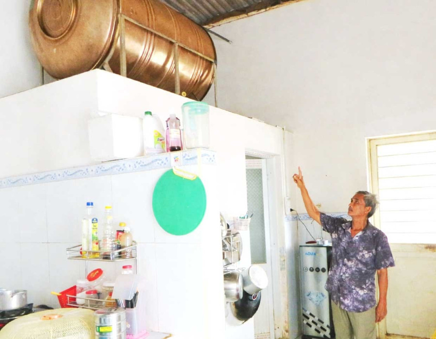 Nước giếng của gia đình ông Nguyễn Văn Sơn bị nhiễm phèn, bồn chứa nước lâu ngày có màu ố vàng, để có nước uống hằng ngày, gia đình ông phải mua máy lọc nước về sử dụng. Ảnh: V.L