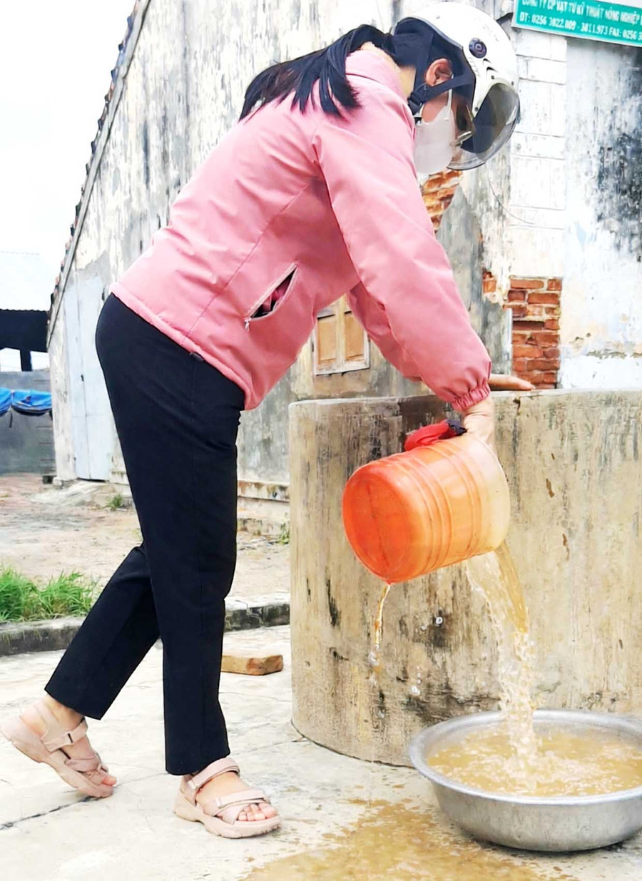 Nước giếng tại nhà bà Trần Thị Hồng bị nhiễm phèn nặng, chưa qua hệ thống lọc có màu vàng nâu. Ảnh: V.L