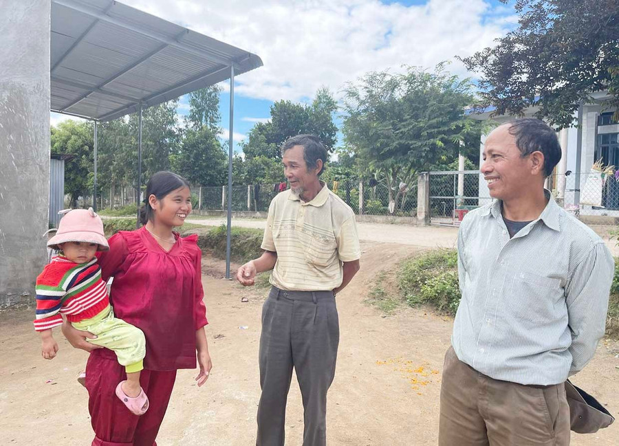 Già Hyek (đứng giữa) và già Djung (bìa phải) trò chuyện cùng người dân trong làng. Ảnh: Phương Dung chot1.jpg