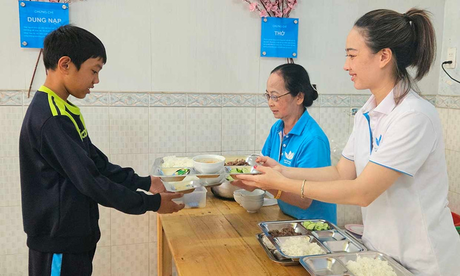 Chị Võ Thị Ngọc Hân (bìa phải), quản lý quán cơm Yên Vui gửi các suất cơm đến bà con. Ảnh: Ngọc Duy them3-4011.jpg