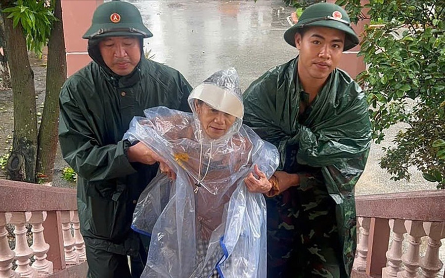 Bà Nguyễn Thị Tuệ (69 tuổi, trú phường Vinh Phú, tỉnh Nghệ An) được các chiến sĩ Lữ đoàn 80 (Quân khu 4) hỗ trợ đến nơi tránh trú bão. Ảnh: MINH HUY Bà Nguyễn Thị Tuệ (69 tuổi, trú phường Vinh Phú, tỉnh Nghệ An) được các chiến sĩ Lữ đoàn 80 (Quân khu 4) hỗ trợ đến nơi tránh trú bão. Ảnh: MINH HUY