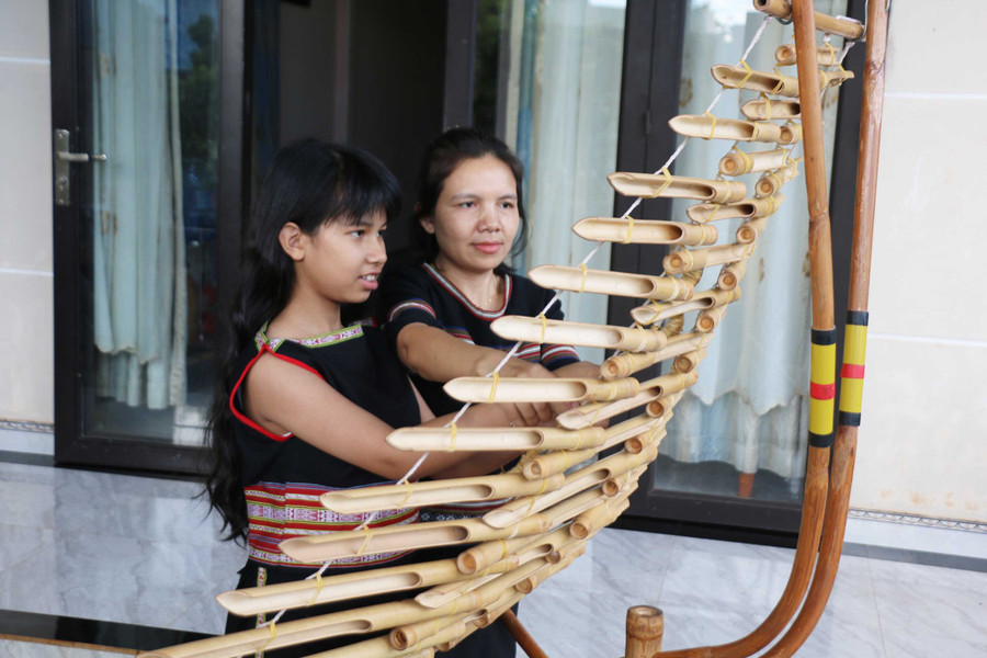 Chị Rcom H'Sonh đang hướng dẫn Srina chơi các bản nhạc hiện đại trên đàn T’rưng. Ảnh: Đồng Lai them5.jpg