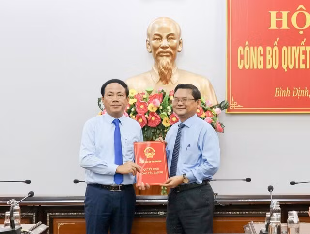 Chủ tịch UBND tỉnh Bình Định Phạm Anh Tuấn (bên trái) trao quyết định cho ông Nguyễn Tự Công Hoàng