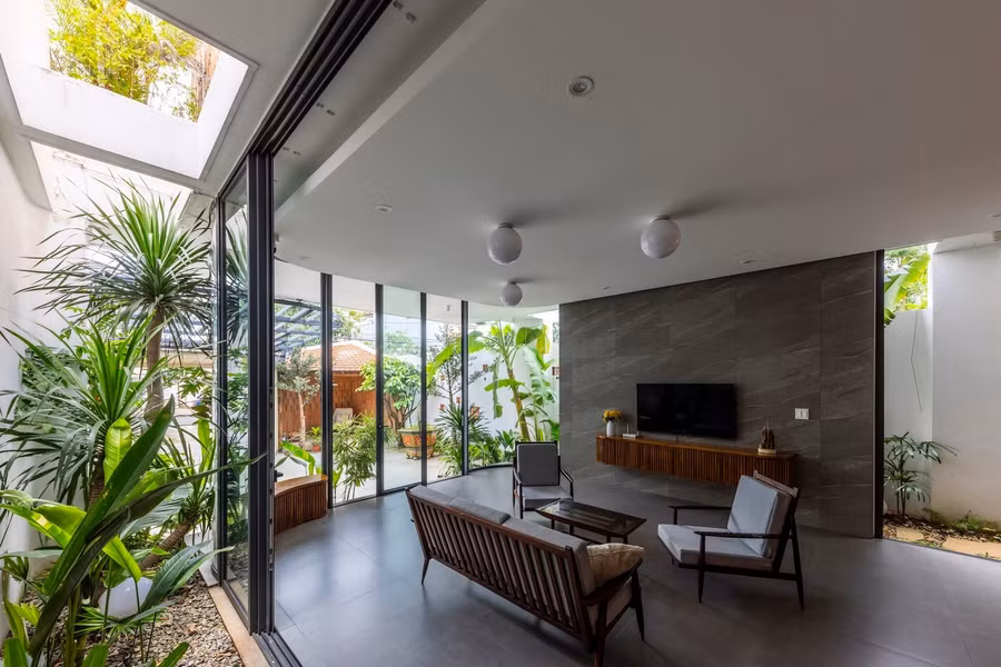 Cây xanh được bố trí hợp lý xung quanh không gian, kết hợp với ánh sáng tự nhiên từ cửa kính, tạo nên môi trường sống trong lành và thoáng mát. Thiết kế này không chỉ mang đến không gian thoải mái cho các hoạt động của gia đình mà còn tăng cường sự kết nối giữa cuộc sống con người với thiên nhiên, mang đến bầu không khí yên bình và thư giãn.