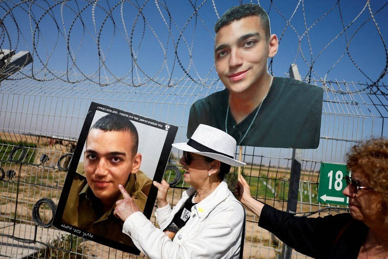 Người thân của binh sĩ Edan Alexander mang theo ảnh của anh tới một sự kiện gần biên giới Israel-Gaza. Ảnh: Reuters nguoi-than-cua-edan-alexander-mang-theo-anh-toi-mot-su-kien-gan-bien-gioi-israel-gaza-anh-reuters.jpg
