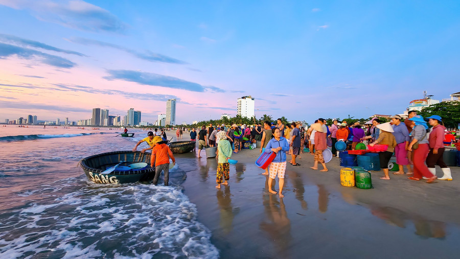 Tấp nập kẻ mua người bán, du khách tham quan chợ cá trên bãi biển. ẢNH: NGUYỄN TRÌNH