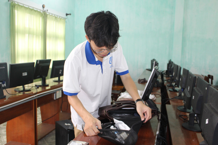 Cao Đăng Khoa, thành viên của đội "Máy tính cũ - Tri thức mới" đang lắp đặt dàn máy vi tính đem tặng cho một trường học ở miền Trung. ẢNH: QUANG VIÊN 3nghiatinh3.jpg