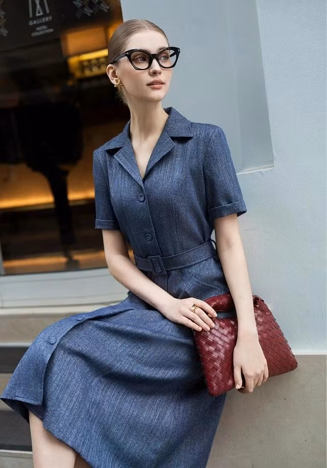 Vẻ đẹp sang trọng, thanh lịch đến từ thiết kế đầm dài cổ vest phối dây lưng hòa quyện trên gam màu xanh đậm của vải denim mềm. ẢNH: NEM FASHION