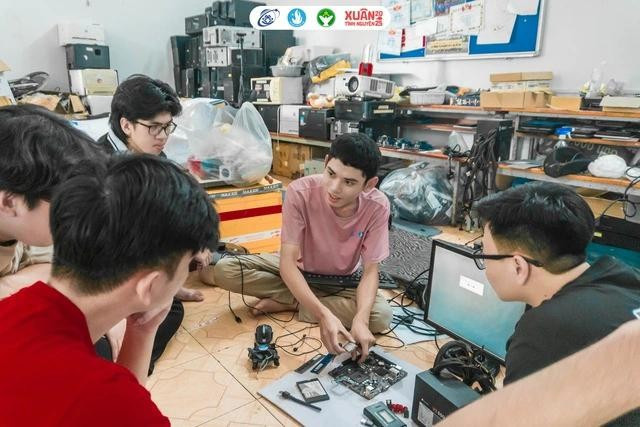 Đội trưởng Phạm Anh Nguyên (áo hồng) đang hướng dẫn sửa chữa, nâng cấp máy tính cho các thành viên trong đội. ẢNH: NVCC 2nghiatinh.jpg