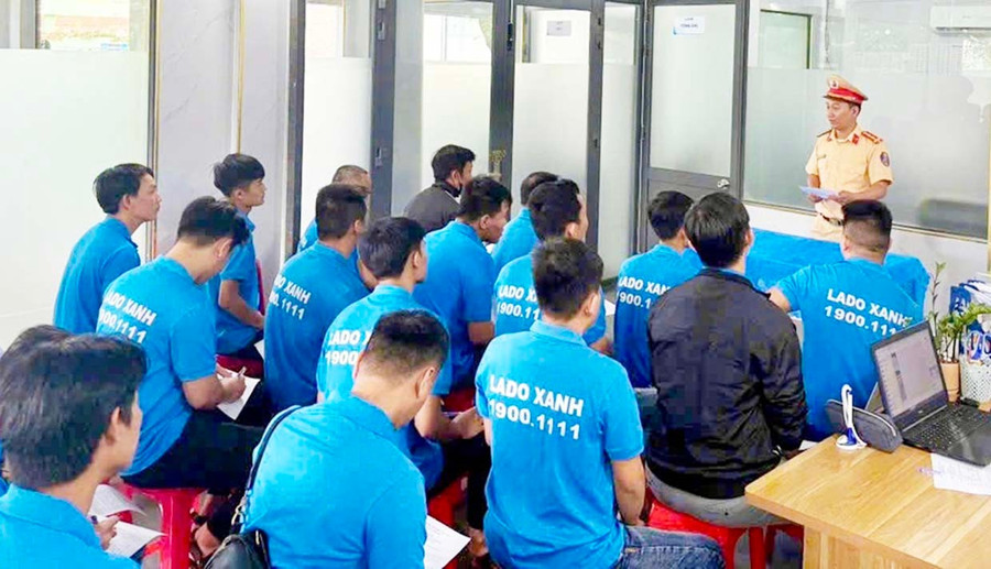 Cán bộ Cảnh sát giao thông (Công an tỉnh) tuyên truyền Luật Trật tự, an toàn giao thông đường bộ cho các tài xế taxi. Ảnh: K.A