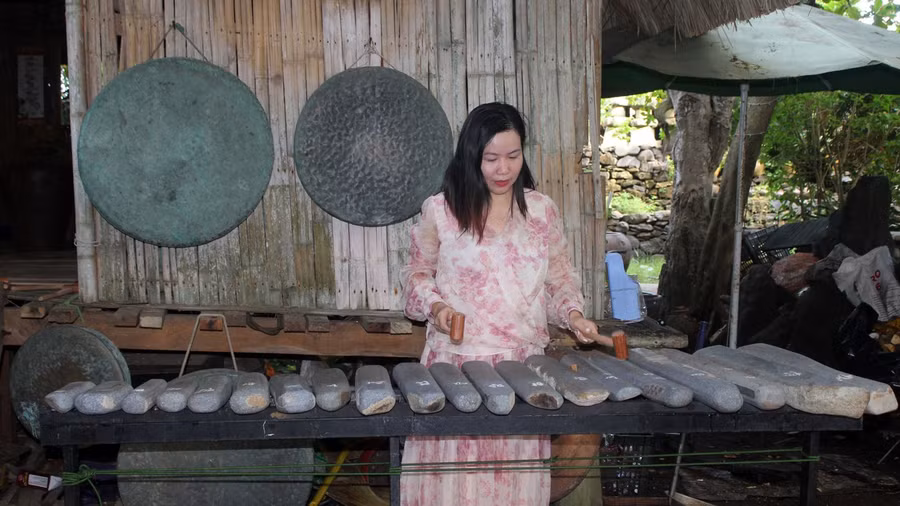 Du khách Nguyễn Thị Thúy Hằng (Hà Nội) đang thử chơi đàn đá. Ảnh: Huyền Oanh