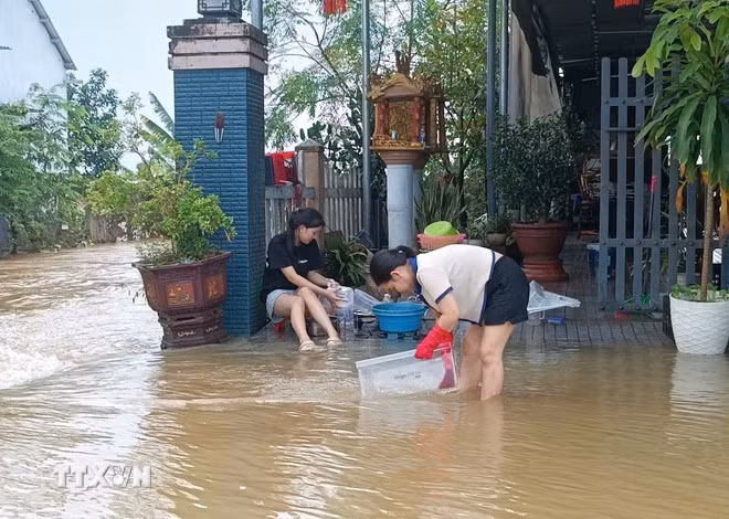 Người dân Huế tất bật dọn dẹp nhà cửa sau lũ. (Ảnh: Hải Âu/TTXVN)