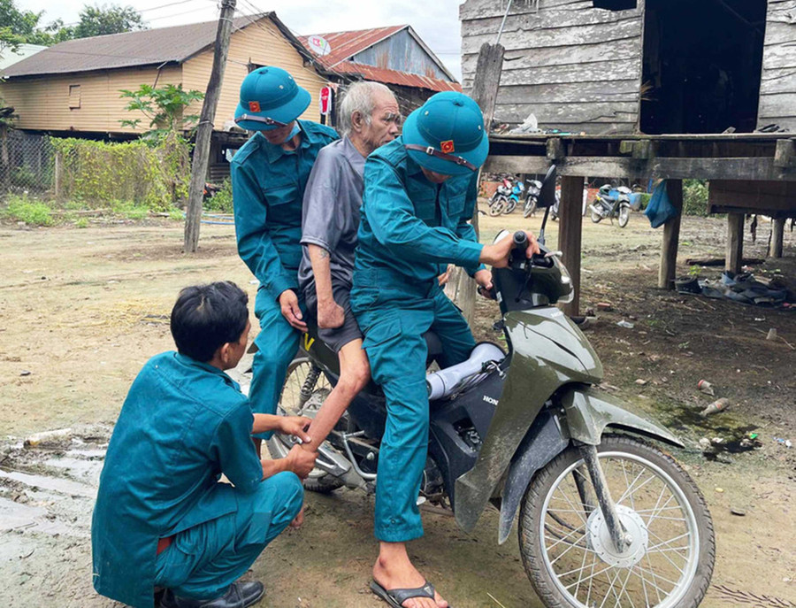 Lực lượng dân quân xã Ia Tul hỗ trợ đưa người già yếu đến nơi sơ tán an toàn. Ảnh: Vũ Chi