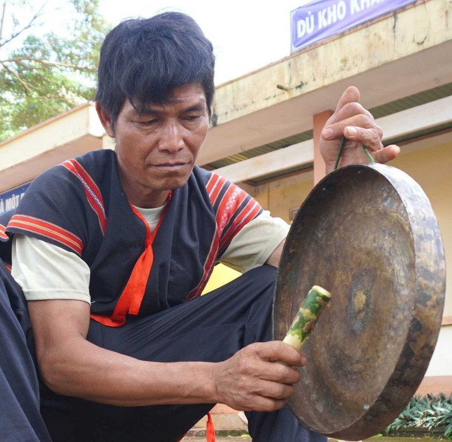 Ông Rơ Châm Kok tỉ mỉ chỉnh từng chiếc chiêng. Ảnh: Chu Hằng