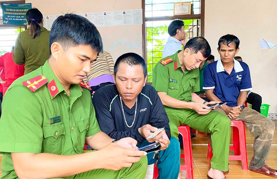 Cán bộ Công an xã Vân Canh về làng Canh Giao kích hoạt tài khoản VNeID cho bà con. Ảnh: N.C