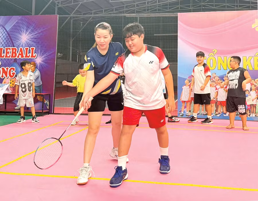 Chị Trương Thị Hà hướng dẫn học sinh tập luyện cầu lông.