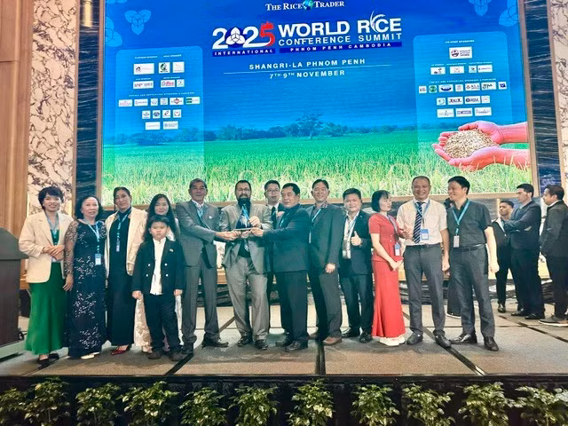 Ông Hồ Quang Cua (bên trái) và ông Đỗ Hà Nam (bên phải) cùng nhận danh hiệu gạo ngon nhất thế giới lần thứ 3 từ Ban tổ chức (đứng giữa) cuộc thi. Ảnh: CTV/TNO