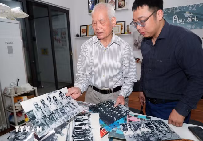 Đại tá phi công Hoàng Biểu giới thiệu những hình ảnh, kỷ vật trong những năm tháng chiến đấu oanh liệt. (Ảnh: Trọng Đức/TTXVN)