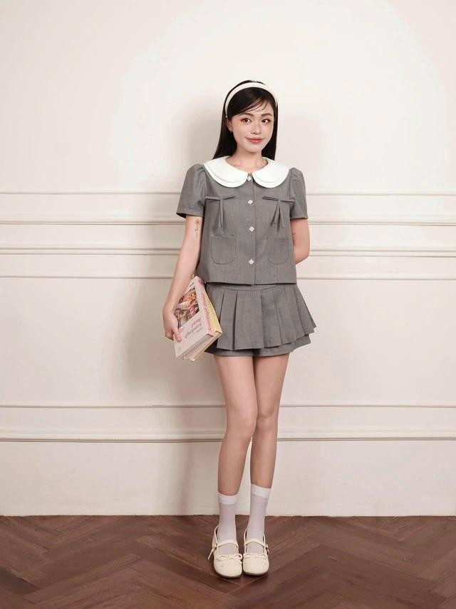 Phom áo lửng giúp hack dáng cực đỉnh, đồng thời tạo hiệu ứng &quot;lưng ngắn chân dài&quot;. Hai chiếc nơ nhỏ xinh trước ngực như điểm xuyết chút duyên dáng, khiến tổng thể trang phục thêm phần nữ tính nhưng không hề &quot;sến&quot;. Chân váy ngắn với thiết kế xếp ly nhẹ, cạp bản to có ưu điểm che khuyết điểm cực tốt. ẢNH: UNI BY HEART