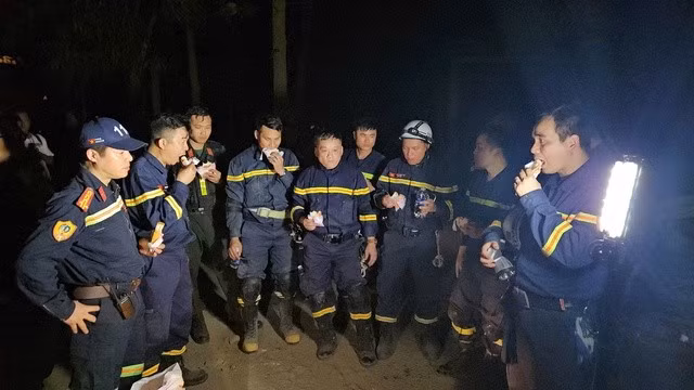 Lực lượng cứu hộ ăn bữa tối nhanh để tiếp tục công việc. Ảnh: C07