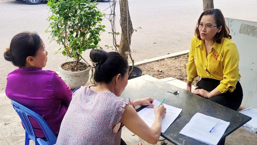 Cán bộ Phòng Kinh tế, Hạ tầng và Đô thị phường Quy Nhơn Đông vận động người dân thôn Nhơn Phước ký cam kết không thả rông trâu, bò ra đường và khu vực công cộng. Ảnh: Văn Lực 2t.jpg