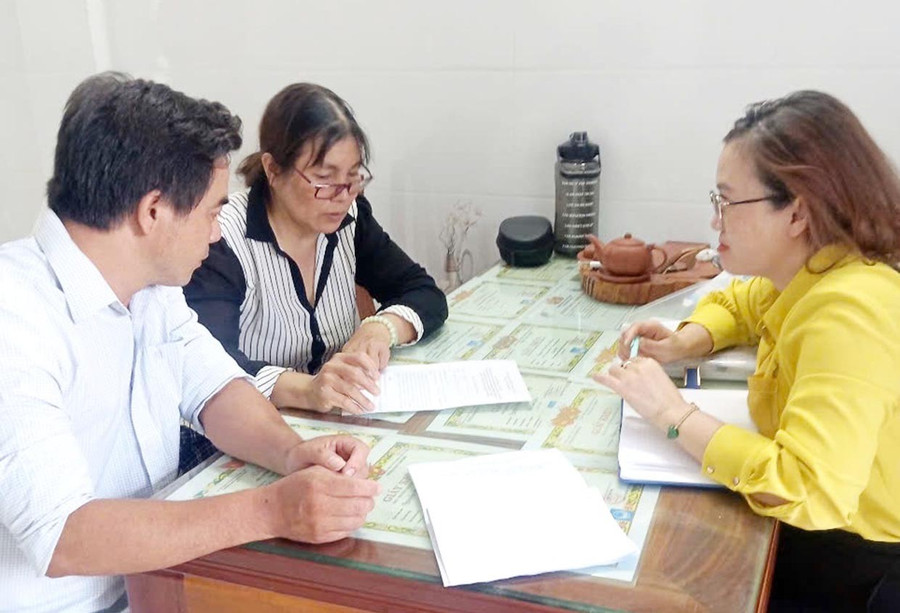 Cán bộ Phòng Kinh tế, Hạ tầng và Đô thị phường Quy Nhơn Đông tuyên truyền, vận động người dân thôn Nhơn Phước ký cam kết không thả rông trâu, bò ra đường và khu vực công cộng. Ảnh: V.L 1c.jpg