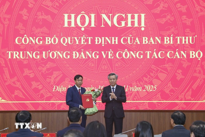 Phó Trưởng Ban Tổ chức Trung ương Nguyễn Quang Dương trao Quyết định và tặng hoa chúc mừng ông Lê Văn Lương. (Ảnh: Xuân Tư/TTXVN)
