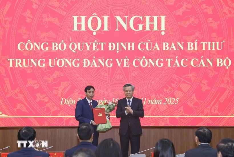 Phó Trưởng Ban Tổ chức Trung ương Nguyễn Quang Dương trao Quyết định và tặng hoa chúc mừng ông Lê Văn Lương. (Ảnh: Xuân Tư/TTXVN)