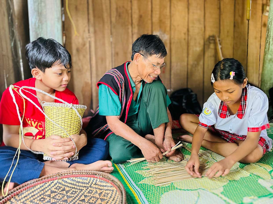 Ông Đinh Văn Rất hướng dẫn các em nhỏ trong làng các kỹ thuật đan đát truyền thống. Ảnh: D.Đ