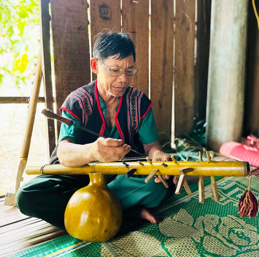 Ông Đinh Văn Rất chế tác, chỉnh dây âm cho cây đàn bầu (preng). Ảnh: D.Đ