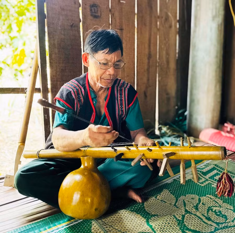 Ông Đinh Văn Rất chế tác, chỉnh dây âm cho cây đàn bầu (preng). Ảnh: D.Đ