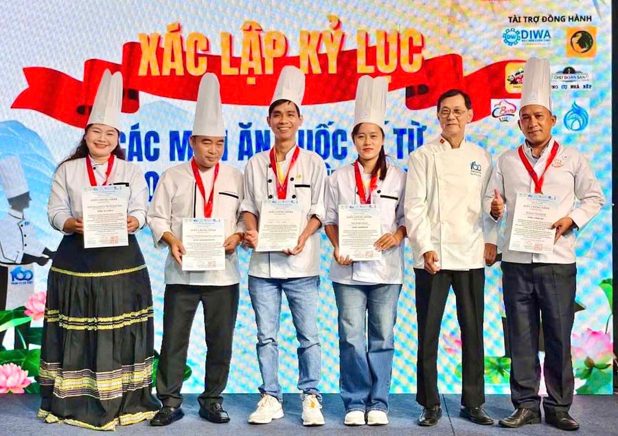 Vũ và Lệ (giữa) được trao giấy chứng nhận tham gia sự kiện chế biến và công diễn cùng lúc các món ăn từ nhiều loại cá nhất Việt Nam vừa qua. Ảnh: NVCC