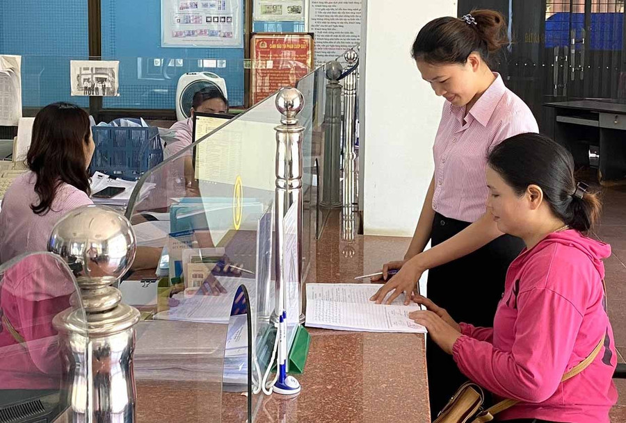 Cán bộ tín dụng Phòng Giao dịch Ngân hàng Chính sách xã hội Hoài Nhơn tư vấn, hướng dẫn người dân các quy định mới của Nghị định số 261/2025/NĐ-CP.