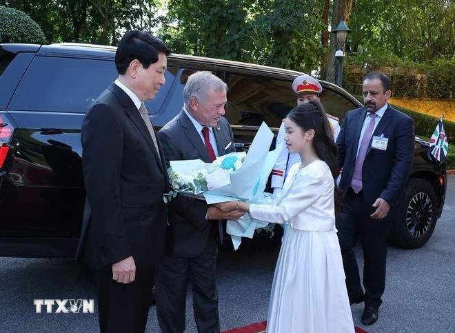 Thiếu nhi Thủ đô Hà Nội tặng hoa Quốc vương Jordan Abdullah II Ibn Al Hussein tại lễ đón. (Ảnh: Lâm Khánh/TTXVN)