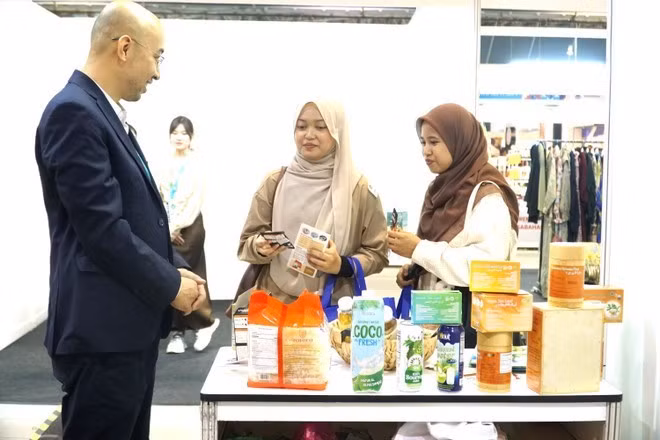 Ông Ngô Quang Hưng, Bí thư thứ Nhất, Văn phòng Thương mại Việt Nam tại Malaysia giới thiệu càphê Việt với bạn bè Malaysia. (Ảnh: Hằng Linh/TTXVN)