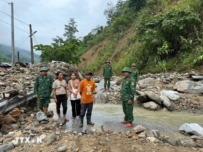 Bộ đội biên phòng Đồn biên phòng Nhôn Mai hướng dẫn người dân không đi qua khu vực sạt lở. Ảnh: TTXVN phát Bộ đội biên phòng Đồn biên phòng Nhôn Mai hướng dẫn người dân không đi qua khu vực sạt lở. Ảnh: TTXVN phát