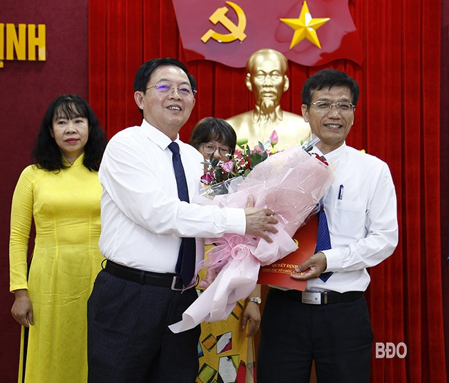 Bí thư Tỉnh ủy Hồ Quốc Dũng trao quyết định bổ nhiệm, tặng hoa chúc mừng đồng chí Hồ Xuân Ánh - Tổng Biên tập Báo Bình Định, giữ chức Tổng Biên tập Báo Bình Định sau hợp nhất. Ảnh: HỒNG PHÚC 3b.jpg