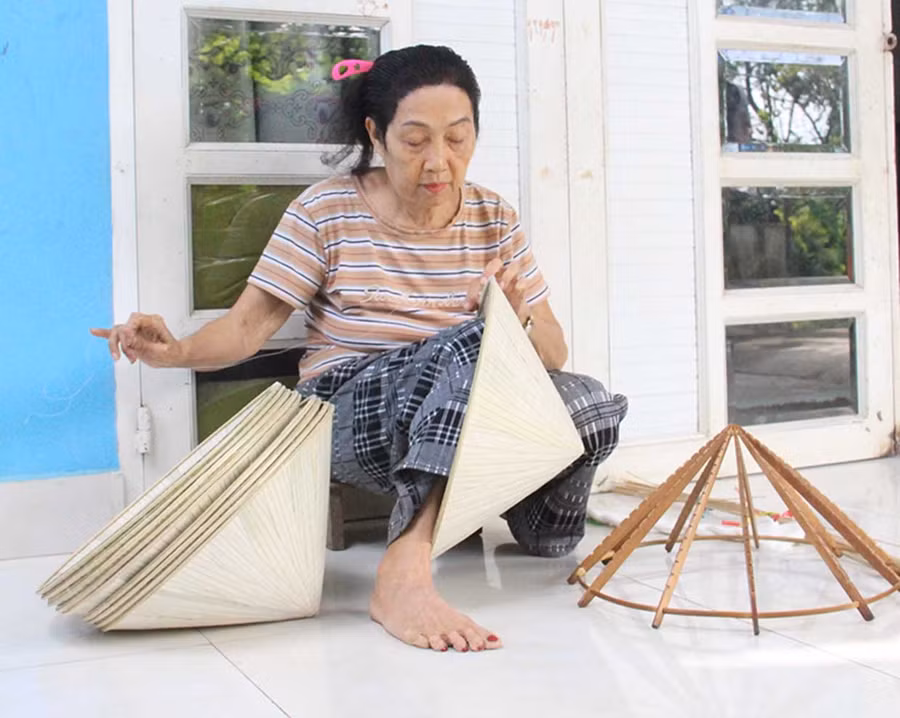Bà Nguyễn Thị Đúng (tổ dân phố Tiên Hội, phường An Nhơn Bắc) vẫn miệt mài với nghề chằm nón lá. Ảnh: Trọng Lợi
