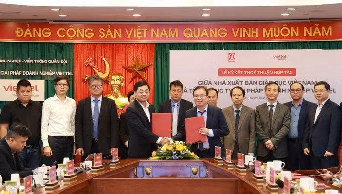 Thanh – Phó Tổng Giám đốc Tổng công ty Giải pháp Doanh nghiệp Viettel trao đổi văn bản thoả thuận hợp tác giữa hai đơn vị. (Ảnh: PV/Vietnam+)