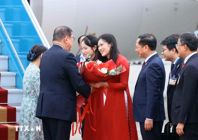 Thiếu nữ Hà Nội tặng hoa, chào mừng Thủ tướng Nhật Bản Ishiba Shigeru và Phu nhân thăm chính thức Việt Nam. Ảnh: An Đăng/TTXVN