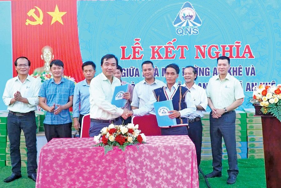 Đại diện Ban Giám đốc Nhà máy Đường An Khê và đại diện làng Hòa Bình (xã Tú An, thị xã An Khê) ký kết bản giao ước kết nghĩa. Ảnh: M.N nha-may-duong-an-khedd.jpg